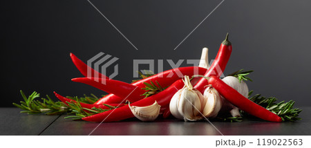 Red hot chili peppers, garlic, and rosemary on a black background. Red hot chili peppers, garlic, and rosemary on a black background. 119022563