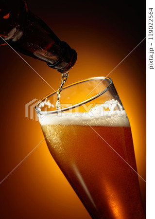 Pouring beer into a tall glass. 119022564
