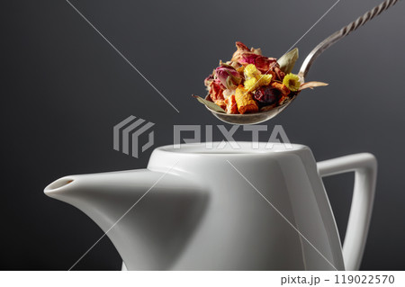 The mix of dried herbs and flowers is poured into the teapot. The mix of dried herbs and flowers is poured into the teapot. 119022570