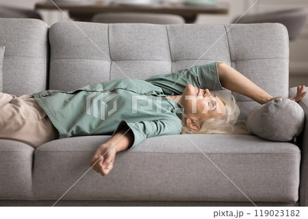 Tired older woman felt asleep on couch Tired older woman felt asleep on couch 119023182