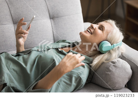Woman wear wireless headphones listening favourite song Woman wear wireless headphones listening favourite song 119023233
