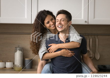 Happy joyful husband piggybacking pretty Latin wife, carrying in arms 119023244