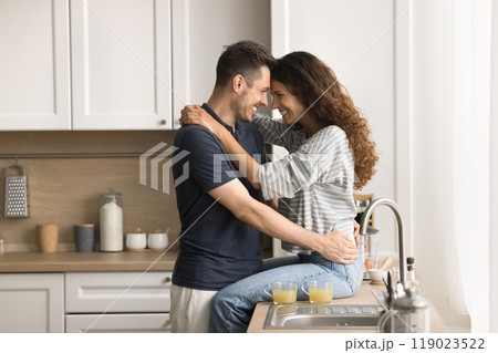 Sweet happy couple hugging with love, affection in kitchen Sweet happy couple hugging with love, affection in kitchen 119023522