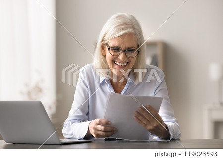 Older woman read document about positive financial statement 119023593