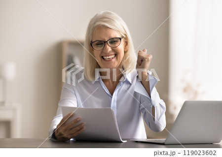 Businesswoman reading great news in paper notification Businesswoman reading great news in paper notification 119023602