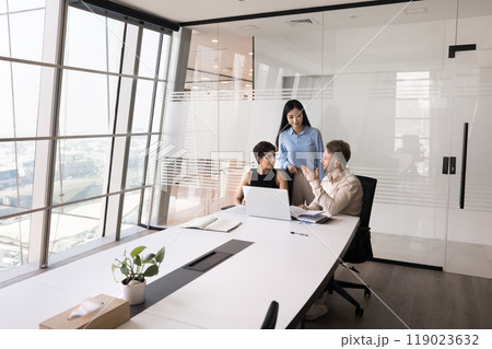 Diverse business project workgroup talking at laptop in meeting room Diverse business project workgroup talking at laptop in meeting room 119023632