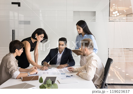 Diverse business group of colleagues discussing paper reports 119023637