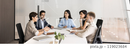 Group of multiethnic coworkers talking at large meeting table Group of multiethnic coworkers talking at large meeting table 119023684