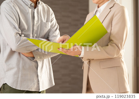 マンションを案内する不動産営業のミドル女性と男性 マンションを案内する不動産営業のミドル女性と男性 119023835
