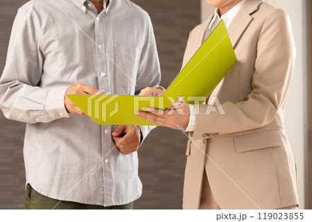 マンションを案内する不動産営業のミドル女性と男性 マンションを案内する不動産営業のミドル女性と男性 119023855