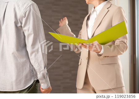 マンションを案内する不動産営業のミドル女性と男性 119023856