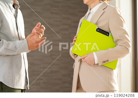 マンションを案内する不動産営業のミドル女性と顧客の男性 119024208