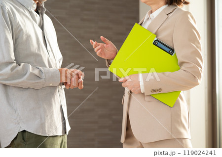 マンションを案内する不動産営業のミドル女性と顧客の男性 119024241