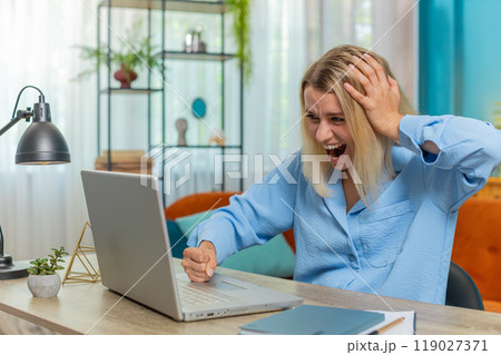 Displeased businesswoman using laptop surprised bad news fortune loss game fail computer virus error Displeased businesswoman using laptop surprised bad news fortune loss game fail computer virus error 119027371