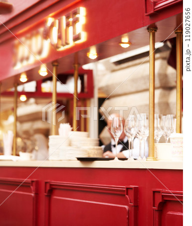 The interior of the restaurant with a red counter and wine glasses and white dishes, a small depth of field      119027656
