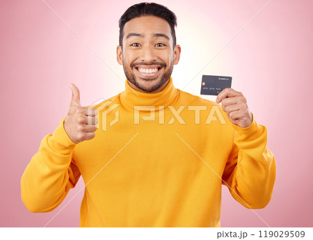 Man, thumbs up and credit card with finance, payment and loan, budget and fashion sale on studio pink background. Portrait, banking success and asian person or gen z for e commerce or shopping emoji Man, thumbs up and credit card with finance, payment and loan, budget and fashion sale on studio pink background. Portrait, banking success and asian person or gen z for e commerce or shopping emoji 119029509
