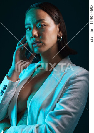 Neon, beauty and portrait of woman in studio with blue light for stylish, classy or formal fashion. Style, cosmetic and young Asian female model with makeup and fancy blazer by dark black background. 119029698