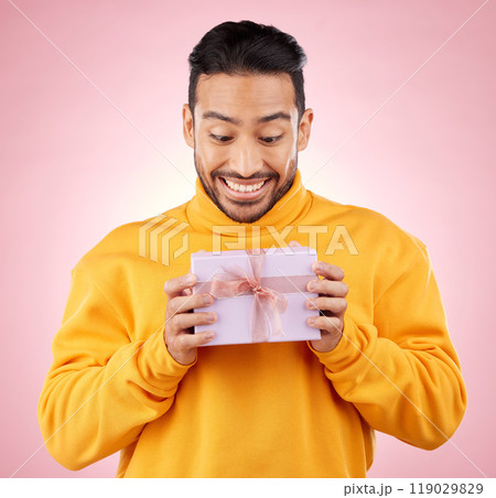 Man, winner and excited for gift box, prize and giveaway celebration or birthday surprise on pink background. Happy person with present, package and retail shopping or competition success in studio Man, winner and excited for gift box, prize and giveaway celebration or birthday surprise on pink background. Happy person with present, package and retail shopping or competition success in studio 119029829