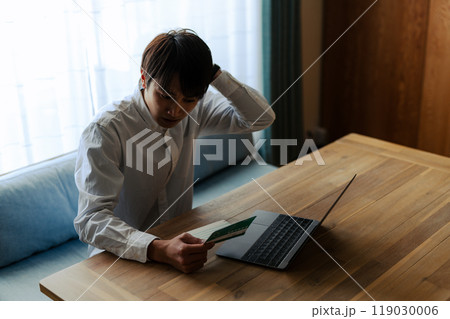 通帳を見る男性 119030006