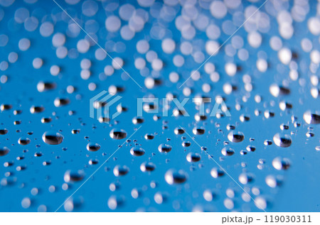Side view of tiny water droplets on a clear blue background. Rain patterns concept 119030311