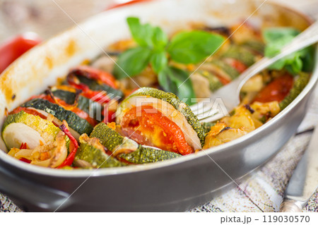 prepared baked zucchini and tomatoes in circles in a ceramic form, vegetable snack prepared baked zucchini and tomatoes in circles in a ceramic form, vegetable snack 119030570