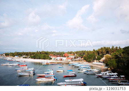 beautiful landscape of fishing boats and tourist speed boats dock at the pier on the coast with cloud and sky the sea beach in Bali island 119031753