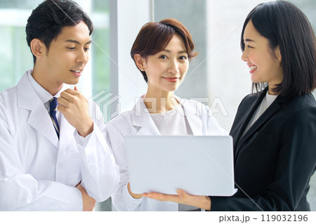 病院で並ぶ白衣の医者とスーツ姿のMRの女性 119032196