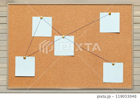 Blank paper notes are pinned to a cork board. The concept of detective investigation or training . Copy space. 119033048