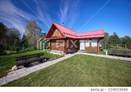 Serene Wooden Cabin Retreat Under Blue Sky 119033698