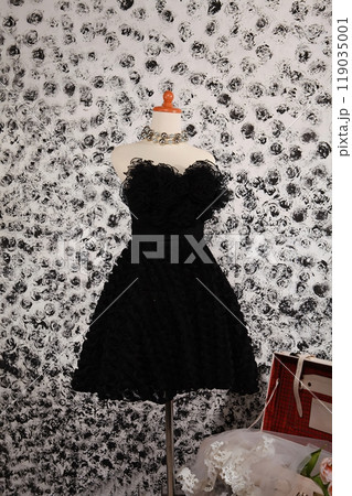Stunning highly fashionable designer woman dress gown for party dress and sociable dress for modern socialite detail displayed on a mannequin in a luxurious background room Stunning highly fashionable designer woman dress gown for party dress and sociable dress for modern socialite detail displayed on a mannequin in a luxurious background room 119035001