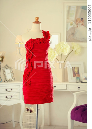 Stunning highly fashionable designer woman dress gown for party dress and sociable dress for modern socialite detail displayed on a mannequin in a luxurious background room 119035005
