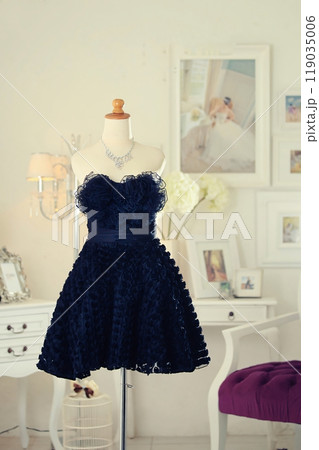 Stunning highly fashionable designer woman dress gown for party dress and sociable dress for modern socialite detail displayed on a mannequin in a luxurious background room 119035006