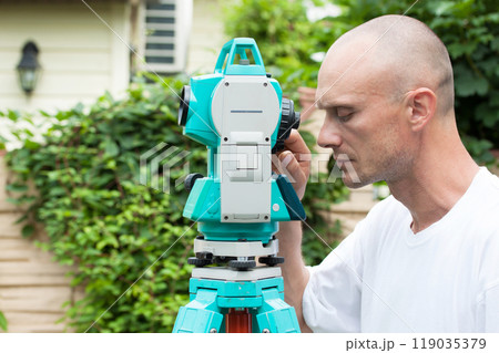 A surveyor works with a total station device 119035379