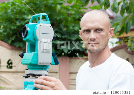 Portrait of an engineer with a total station device 119035381