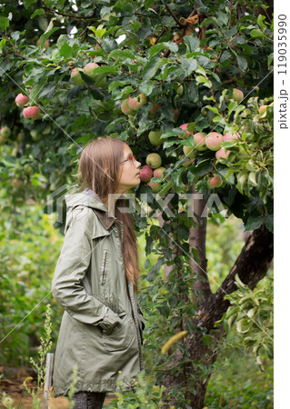 A teenage girl near a apple tree in the garden 119035990