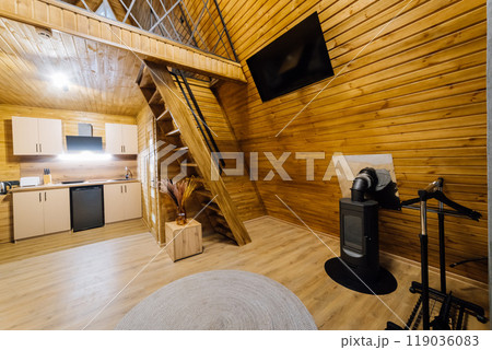 Modern wooden cabin interior with kitchen and loft area, perfect for relaxation and cozy retreats Modern wooden cabin interior with kitchen and loft area, perfect for relaxation and cozy retreats 119036083