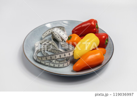 Plate with sweet peppers and a measuring tape. Concept of diet and weight loss 119036997