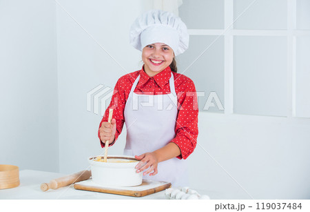 at home. Child and baking. Healthy eating and lifestyle concept. girl making dough from flour and eggs. dieting and health. culinary school. traditional cuisine. kid having fun with food at kitchen 119037484