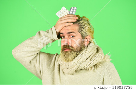 Sick man hold tablets. Buy medicines. Virus fever. Vitamin supplements. Immune system fight infections. Bacteria invades body. Virus treatment. Virus pneumonia. Bearded hipster messy hairstyle Sick man hold tablets. Buy medicines. Virus fever. Vitamin supplements. Immune system fight infections. Bacteria invades body. Virus treatment. Virus pneumonia. Bearded hipster messy hairstyle 119037759