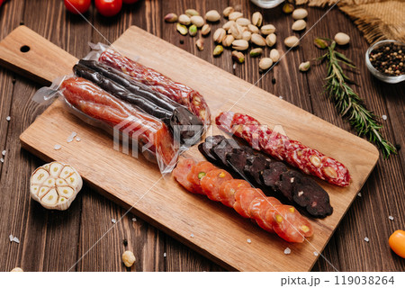 Assorted gourmet salami slices with nuts and spices on board, charcuterie and deli platters Assorted gourmet salami slices with nuts and spices on board, charcuterie and deli platters 119038264
