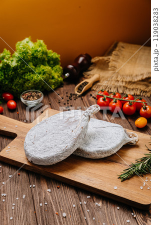 Dry-cured salami on board, ideal for rustic charcuterie presentations and gourmet food styling 119038283