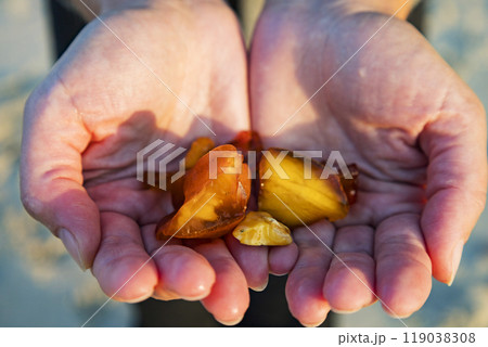 A person is gently holding a beautiful piece of amber A person is gently holding a beautiful piece of amber 119038308