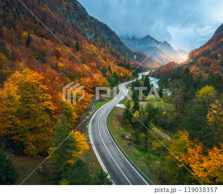 Aerial view of curvy road and orange forest in mountains in fall Aerial view of curvy road and orange forest in mountains in fall 119038357