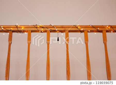 the wooden railing of the stairs is decorated with a Christmas garland the wooden railing of the stairs is decorated with a Christmas garland 119039075
