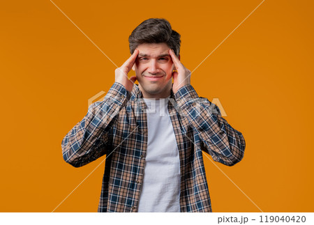 Mature man having hypertension headache, yellow studio.Guy putting hands on head Mature man having hypertension headache, yellow studio.Guy putting hands on head 119040420