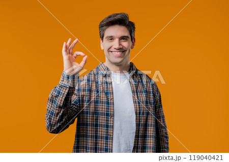 Positive mature 30s man makes OK, okay hand sign gesture.Happy student on yellow 119040421