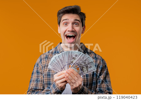 Rich excited man, cash money USD currency dollars banknotes on yellow,jackpot 119040423