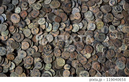 Top view of Ancient Roman coins on dark wooden table, pile of old bronze money, vintage background. Concept of antique, Empire, Rome, texture, civilization Top view of Ancient Roman coins on dark wooden table, pile of old bronze money, vintage background. Concept of antique, Empire, Rome, texture, civilization 119040658