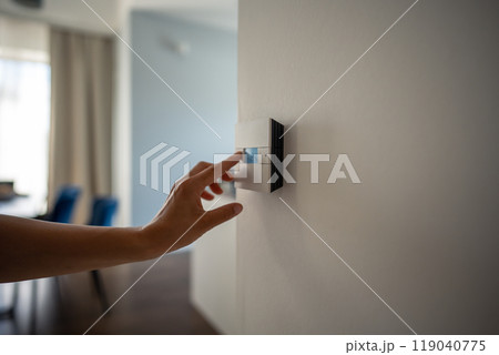 Woman hand adjusts underfloor heating settings in smart home panel for comfort in cold season Woman hand adjusts underfloor heating settings in smart home panel for comfort in cold season 119040775