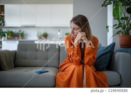 Worried woman sadly looking at smartphone wait call or important news feeling solitude, frustration. 119040886